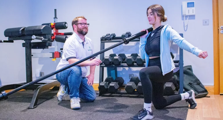 Athlete doing a strength exercise with a therapist in the Just One Body gym