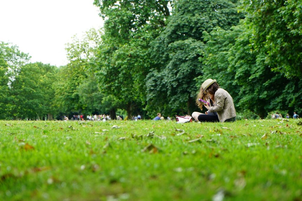 Woman sitting outdoors with trees & green space