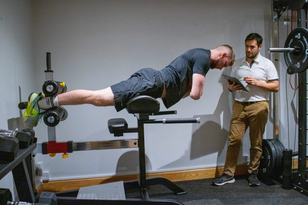 Kieran Lowe supervising a back extension exercise in the Just One Body gym