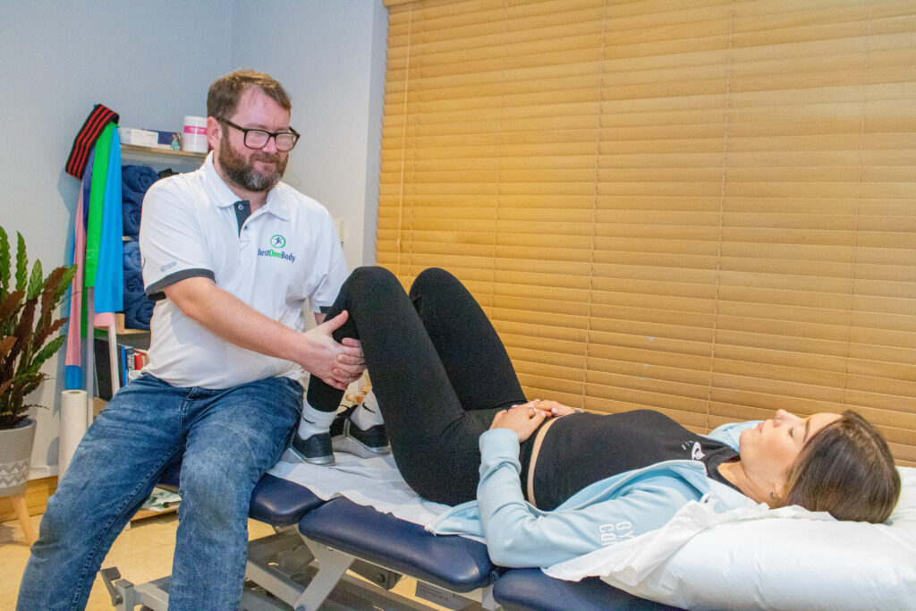 Brian O'Shea treating a patient's hip and knee at Just One Body