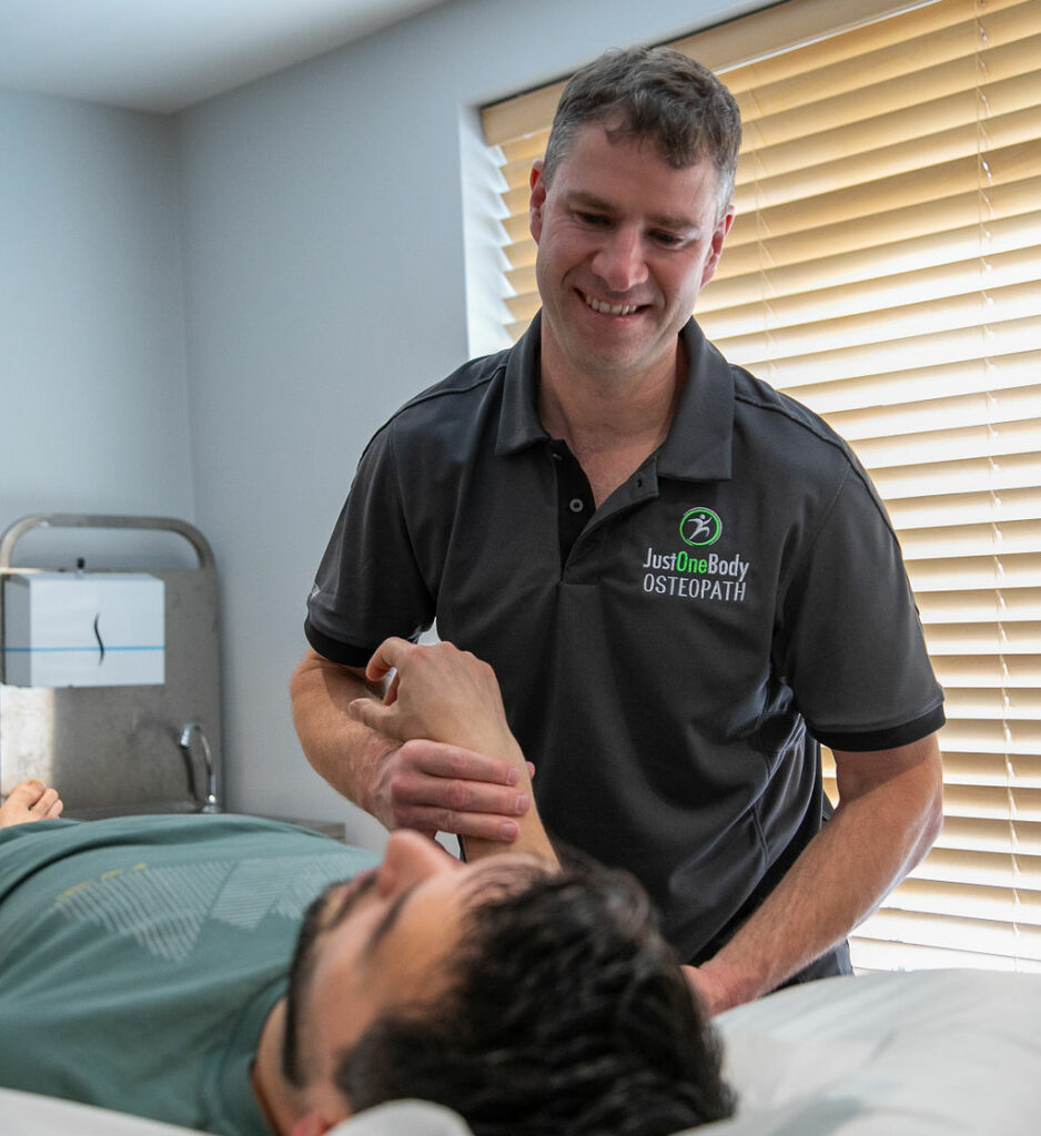 Osteopath treating a patient's leg at Just One Body