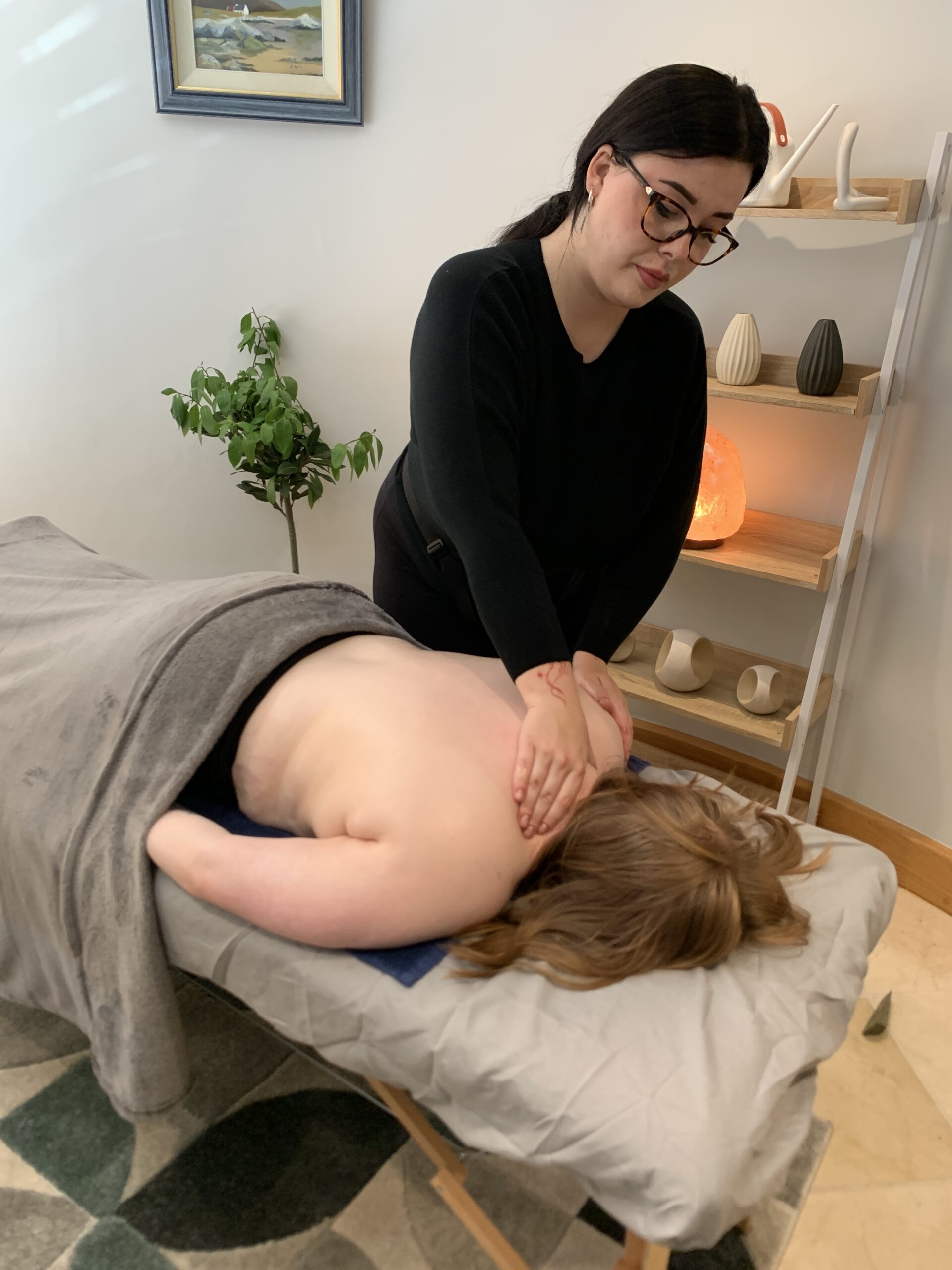 Weronika giving a back massage in the treatment room at Just One Body